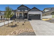 Charming home with a two-car garage, covered porch, rock landscaping, and gray and white color scheme at 39867 Floyd St, Elizabeth, CO 80107