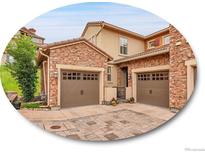 Beautiful home exterior featuring brick accents, a two-car garage, and well-maintained landscaping at 9246 Sori Ln, Highlands Ranch, CO 80126