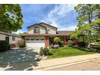 Charming two-story home with a well-maintained lawn, red accents, mature trees, and an attached two-car garage at 2912 Lake Park Way, Longmont, CO 80503