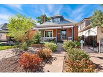 Charming brick home with a covered porch and beautifully landscaped front yard, perfect for curb appeal at 511 S Pennsylvania St, Denver, CO 80209