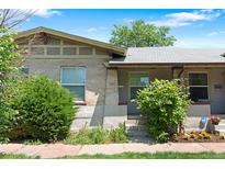 Charming bungalow with brick and stucco exterior, featuring a well-maintained front yard and cozy entrance at 1211 E 26Th Ave, Denver, CO 80205