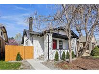 Charming white brick home with a red front door and a well-manicured front yard, enhancing curb appeal at 1209 Harrison St, Denver, CO 80206