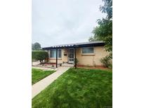 Cozy brick home with covered entry and lush green lawn at 3000 Billings St, Aurora, CO 80011