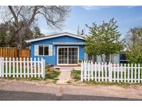 Charming blue home features a white picket fence and inviting front yard at 6445 Second St, Louviers, CO 80131