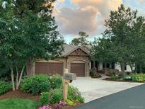 Beautiful stone home featuring a two-car garage, lush landscaping, and a welcoming driveway at 646 Ruby Trust Dr, Castle Rock, CO 80108
