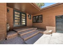 Charming home entrance with double doors and brick steps at 8782 S Ault Ln, Morrison, CO 80465