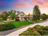 Charming home with brick and stone exterior, manicured lawn, and beautiful landscaping at 17053 E Jamison Ave, Centennial, CO 80016