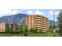 Brick apartment building featuring multiple balconies with mountain views and a green lawn at 850 20Th St # 201, Boulder, CO 80302