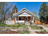 Charming brick bungalow featuring a landscaped front yard and inviting front porch on a sunny day at 3725 S Acoma St, Englewood, CO 80110