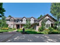 Stunning two-story home with brick and siding exterior, lush landscaping, and a spacious driveway at 4845 S Gaylord St, Cherry Hills Village, CO 80113