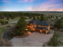 Stunning aerial view of a home on a large lot with a circular driveway and mountain views at 7465 Kelty Trl, Franktown, CO 80116
