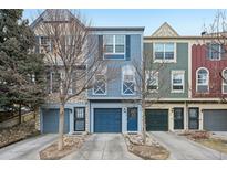 Charming townhomes with colorful facades, attached garages, and well-maintained landscaping on a sunny day at 912 S Paris Ct, Aurora, CO 80012