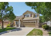 Charming two-story home featuring manicured lawn, mature trees, and a spacious two car garage at 7371 S Mobile St, Aurora, CO 80016