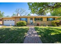 Charming single-story home with a well-manicured lawn, brick accents, and a welcoming brick pathway at 2744 S Newton Way, Denver, CO 80236
