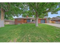 Charming brick home with a well-manicured lawn and mature trees at 4320 Teller St, Wheat Ridge, CO 80033