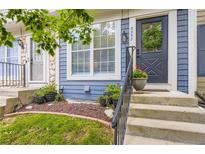 Inviting front entrance with a black door, complemented by decorative plants and manicured lawn at 8252 S Fillmore Cir, Centennial, CO 80122