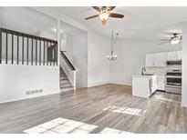 Spacious living room with hardwood floors, lots of natural light, stairs to 2nd floor, and kitchen at 10731 W 63Rd Ave # A, Arvada, CO 80004