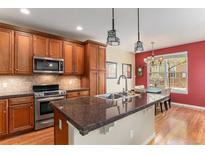 Modern kitchen features stainless steel appliances, granite countertops, and custom cabinets at 11962 W Long Cir # 103, Littleton, CO 80127
