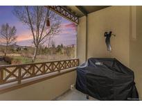 Cozy outdoor patio features a grill and golf decor with scenic views of the golf course at 11962 W Long Cir # 103, Littleton, CO 80127