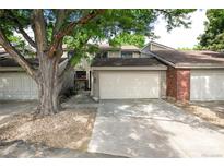 Inviting townhouse featuring an attached two-car garage, well-maintained landscaping, and a charming entryway at 7925 W Layton Ave # 605, Littleton, CO 80123