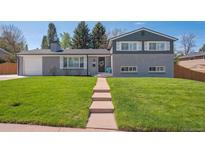 Beautiful two-story home features a brick facade, well-manicured lawn, and inviting front entrance at 8242 E Briarwood Pl, Centennial, CO 80112