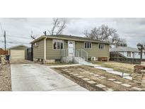 Charming home featuring a quaint front yard, long driveway, and single car detached garage at 7770 Kenwood St, Commerce City, CO 80022