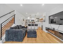 Open concept living room with hardwood floors and modern kitchen at 1403 Yates St, Denver, CO 80204