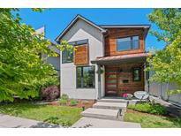 Modern two-story home featuring a red front door and a mix of white siding and stained wood accents at 3425 W Moncrieff Pl, Denver, CO 80211