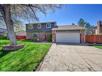 Charming two-story home with a well-manicured lawn, brick accents and a two car garage on a sunny day at 6527 S Yarrow Way, Littleton, CO 80123