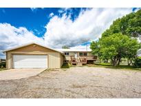 Charming home featuring an attached garage and inviting wood deck at 73 N Dutch Valley Rd, Bennett, CO 80102