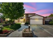 Charming two-story home with a lush front yard, brick accents, and a two-car garage on a twilight at 3870 S Ouray Way, Aurora, CO 80013