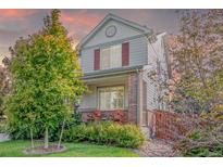Exterior of a two-story home with red shutters, a brick accent, and manicured landscaping at 129 N Irvington St, Aurora, CO 80018