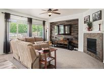 Inviting living room features a modern fireplace, wood accent wall, and comfortable seating area at 3834 Donnington Cir, Castle Rock, CO 80104