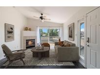 Bright living room with fireplace, balcony, and modern decor, creating a cozy atmosphere at 3825 Canyon Ranch Rd # 203, Highlands Ranch, CO 80126