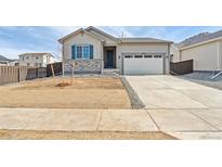 Charming single Gathering home features a two-car garage and stone exterior accents at 9742 Cathay St, Commerce City, CO 80022