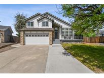 Charming two-story home featuring a stone facade, attached two-car garage, and inviting front porch at 19131 E Garden Pl, Centennial, CO 80015