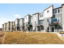 Modern townhomes feature gray siding, balconies, and contemporary architectural details on a sunny day at 2672 W 68Th Ave, Denver, CO 80221