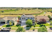 Charming two-story home featuring a well-manicured front yard and a two car garage at 12400 Village Cir, Brighton, CO 80603