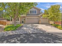 Charming home featuring a well-manicured lawn, mature trees, and a spacious three-car garage at 2938 S Zeno Way, Aurora, CO 80013