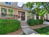 Charming townhome featuring stone accents, manicured landscaping, and a welcoming entrance at 9758 Laredo St # 35B, Commerce City, CO 80022