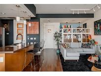 Open concept living room featuring modern design elements, stylish furniture, and decorative art at 2460 W 29Th Ave # 104, Denver, CO 80211