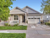 Charming single-story home with a covered porch, attached garage, and well-maintained lawn at 18280 W 85Th Dr, Arvada, CO 80007