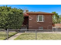 Charming brick home featuring a well-manicured lawn and mature landscaping at 2291 W 54Th Ave, Denver, CO 80221