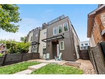 Modern two-story home featuring unique architectural design and a cozy front yard with landscaping and seating at 4557 Stuart St, Denver, CO 80212