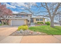 Charming two-story home with a well-manicured lawn, mature trees, and an attached two-car garage at 2194 S Braun Way, Lakewood, CO 80228