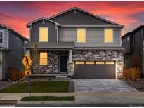Beautiful two-story home featuring stone accents, gray siding, and a two-car garage at 553 Homestead Ave, Brighton, CO 80601