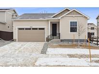 Inviting exterior view of home with a two car garage, black front door and landscaped front yard at 9693 Ceylon St, Commerce City, CO 80022