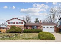 Charming brick home with a well-maintained lawn, mature landscaping, and an attached two-car garage at 10830 Claire Ln, Northglenn, CO 80234