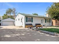 Charming home with a well-maintained front yard, benches, and a detached two car garage at 7891 Poplar St, Commerce City, CO 80022