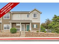 Charming multi-level townhome with two-tone siding, a brick foundation, and a welcoming covered porch at 14700 E 104Th Ave # 2802, Commerce City, CO 80022